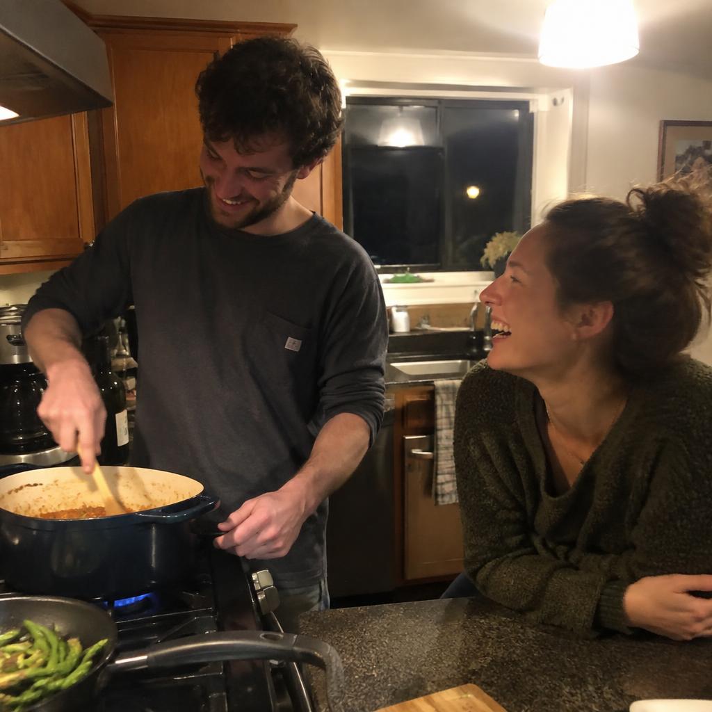 A candid photo of a couple cooking dinner together in their kitchen at night, laughing
